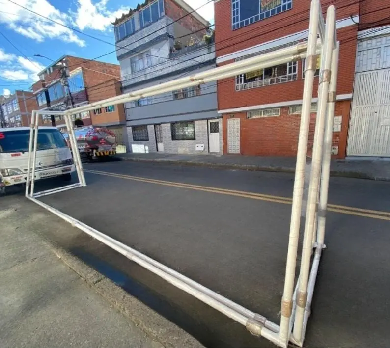 Arco de fútbol blanco de tubo grande en fabricación, sobre la calle